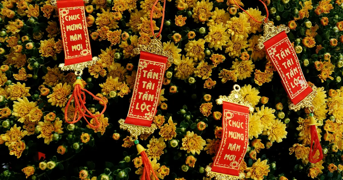 Thẻ đỏ Chúc mừng năm mới, Tấn tài tấn lộc treo trên chậu cúc vàng ngày Tết